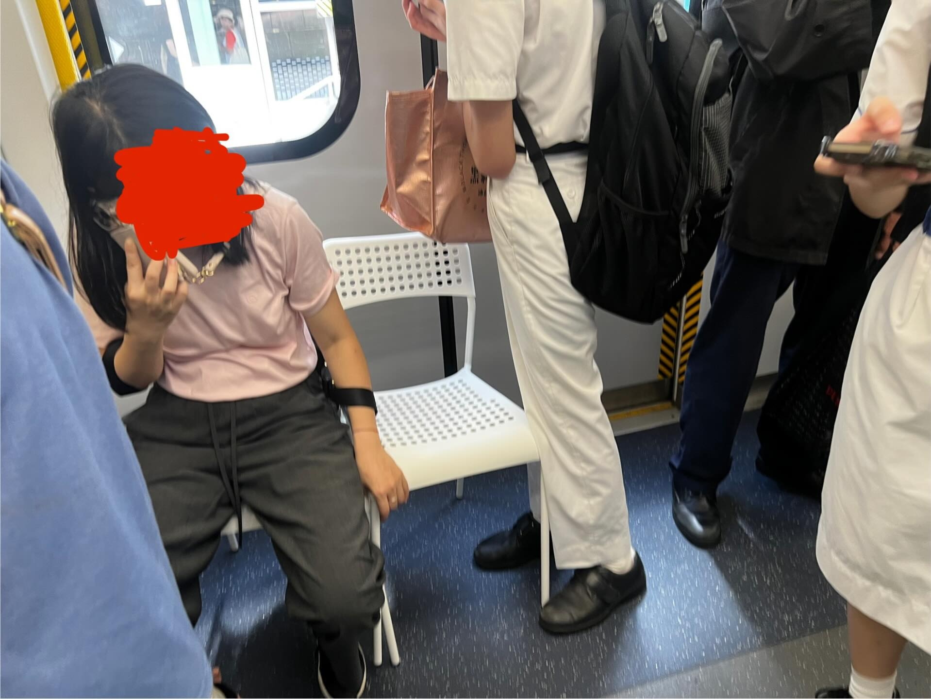涉事長髮女乘客正拿著手機說話，疑似帶同兩張白色膠椅乘搭港鐵，並在車廂的門口位置，並排放置兩張椅子，自己坐一張，另一張空椅則用手扶著，兩張椅子佔據了車門約一半位置。當時車廂內站有多名乘客，當中有一名男學生正貼著椅子站立。（Threads圖片／oof_sharkcat）