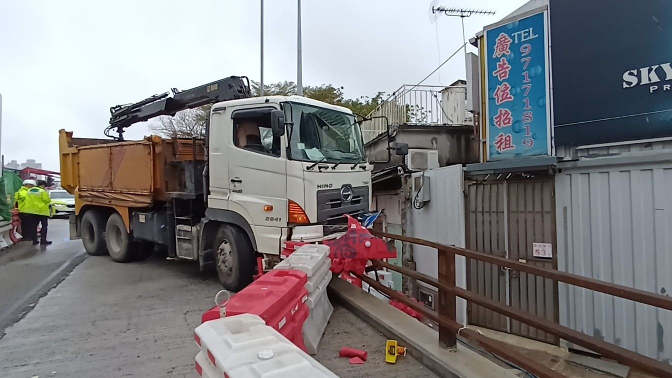 元朗吊臂車疑天雨路滑失控，撞欄及水馬更險衝入村屋。