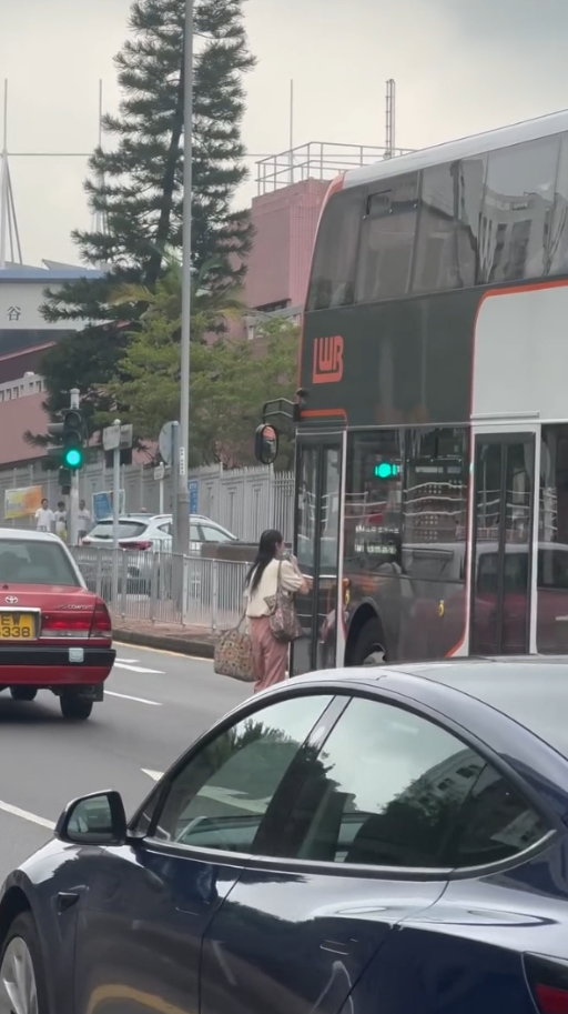 女子荃灣衝馬路拍門追巴士勁牙煙，司機終開門放行被網民鬧爆。(影片截圖／Threads@z.oeyi)