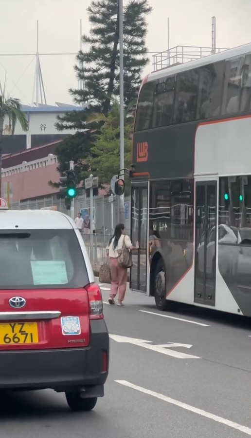 女子荃灣衝馬路拍門追巴士勁牙煙，司機終開門放行被網民鬧爆。(影片截圖／Threads@z.oeyi)