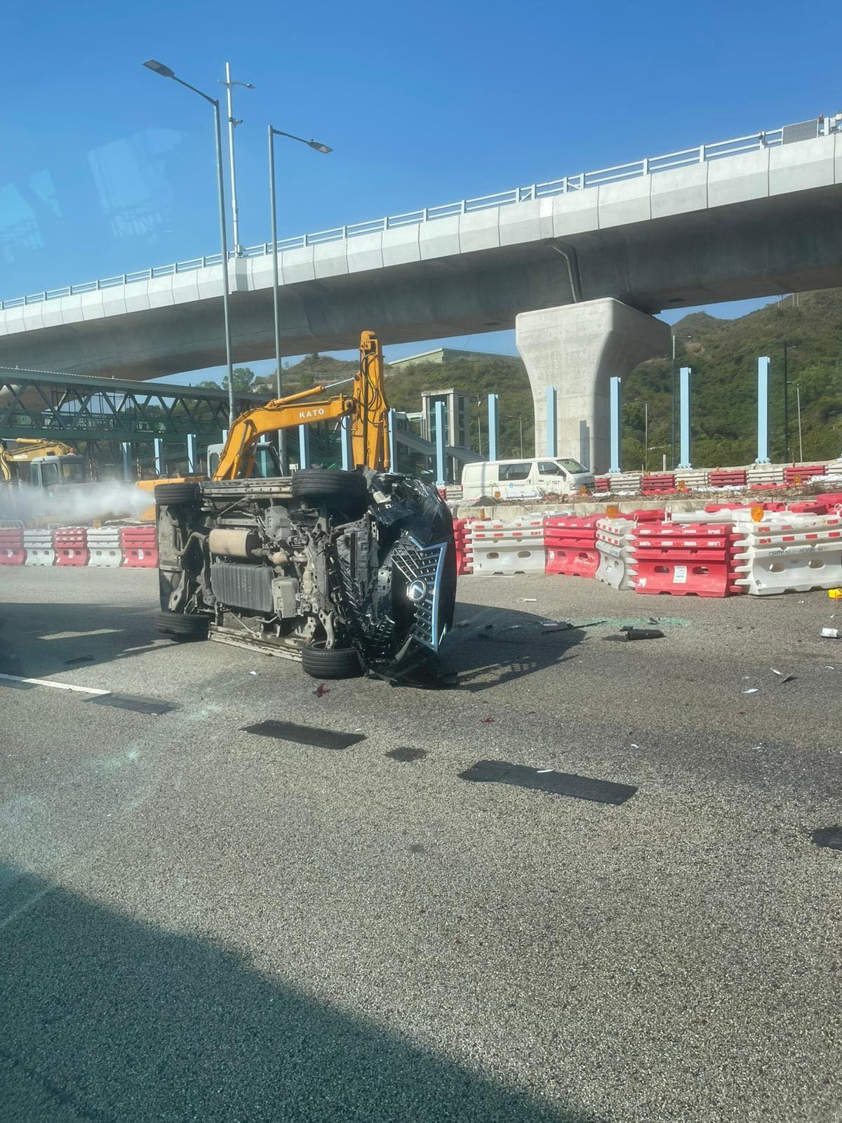 涉事黑色私家車向左翻側，橫亘路中，車尾冒白煙，車頭嚴重損毀，零件碎片散落一地。（Facebook圖片／車cam L（香港群組）／Bosco Chu）