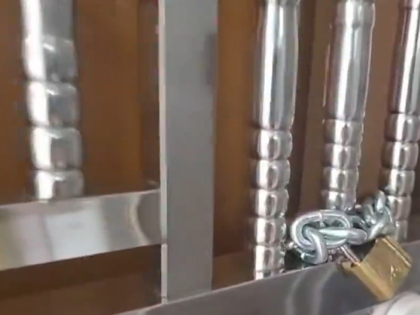 案發單位門外鐵閘以鐵鏈上鎖，大門半掩，可見睡房床邊和單位地上均有血跡。