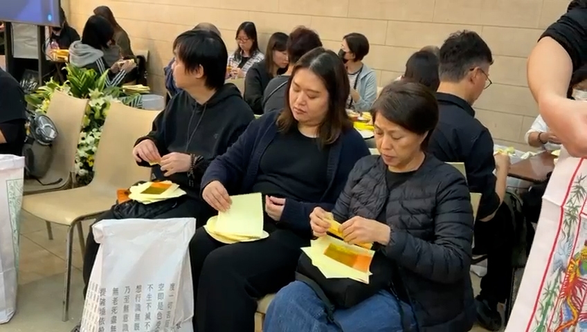 報料觀眾指，下午三時左右開始陸陸續續有市民到九龍殯儀館為死難者摺衣紙，黃昏後越來越多熱心市民到場，盡一番心意鞠躬以及獻花。（報料觀眾提供影片截圖）