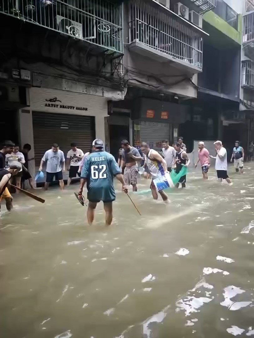 在澳門水浸的街道上，有民眾在嘗試捉魚，以及成功將新鮮魚撿走。（Threads影片截圖／cclwss）