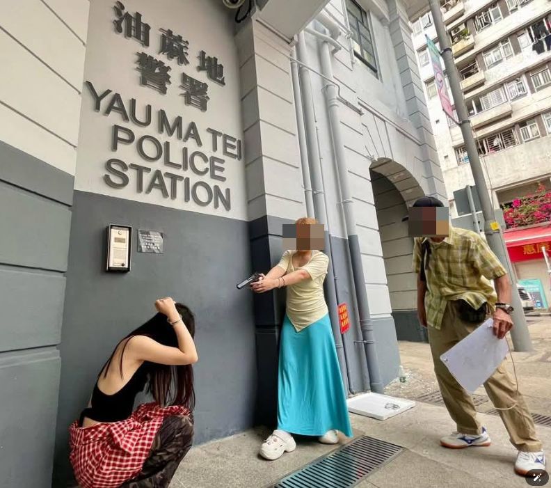 舊油麻地警署外內地客持仿製槍拍照