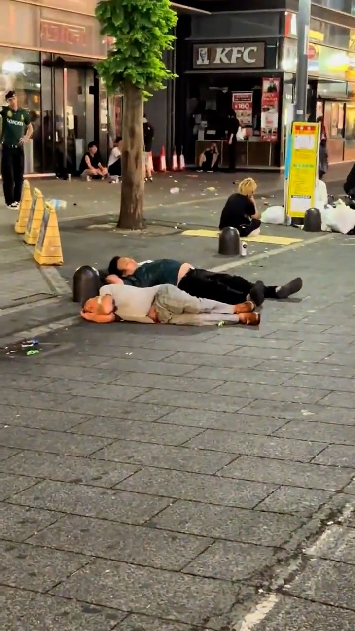 路人亦將鏡頭拍向街上，顯示有人躺在地上呼呼大睡。（「X」影片截圖／alex001050）