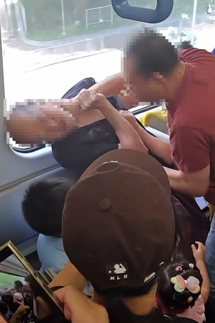 紅衣男表現激動，對禿頭男施以叉頸，並將對方壓向附近座位。（Facebook影片截圖／車cam L（香港群組）／Soso Chan）