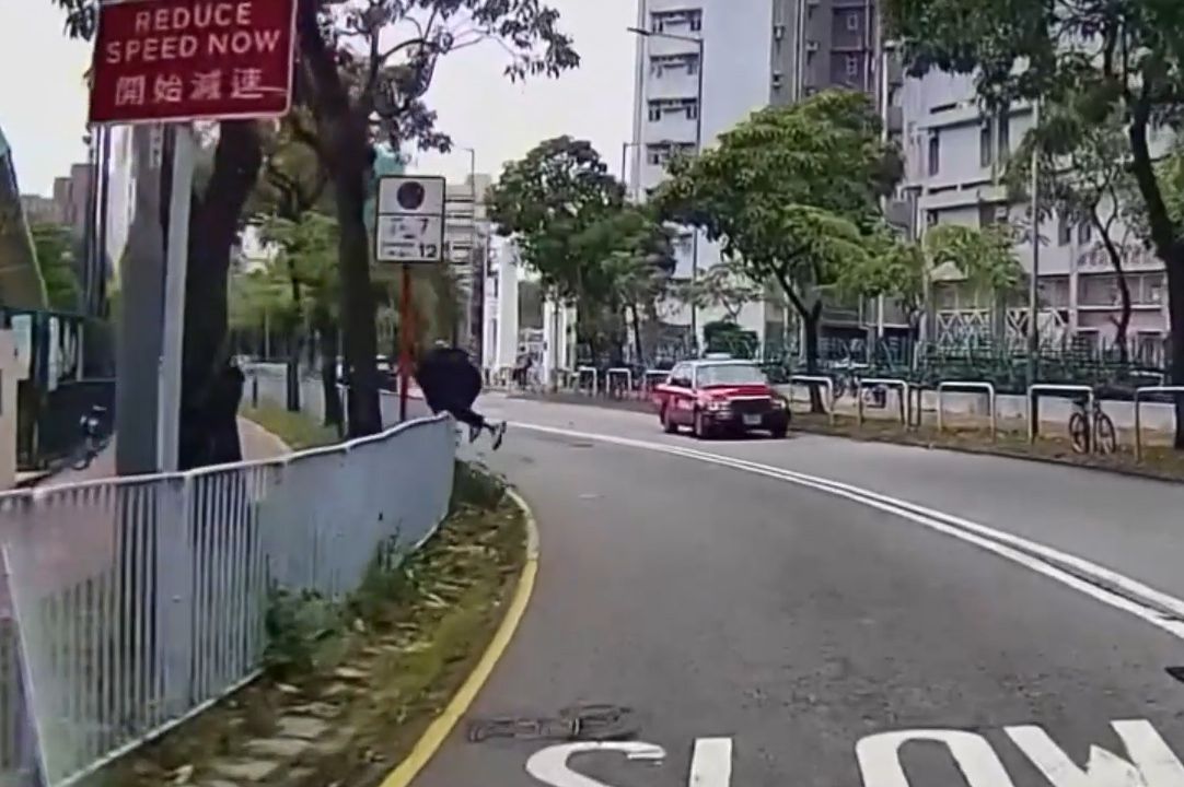 香港男子違規過馬路跨欄，慘變「另類炒車」過程全拍下。(影片截圖)