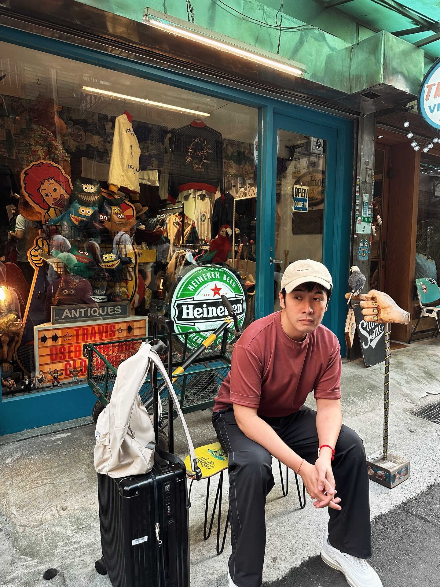 May be an image of 3 people, hat shop, newsstand, street and text that says 'M4 VI 00 99 JAUWEN HEINEKEN BEED ANT IQUES ANTIQUES ES Heine en Ctasp 다 RISU'