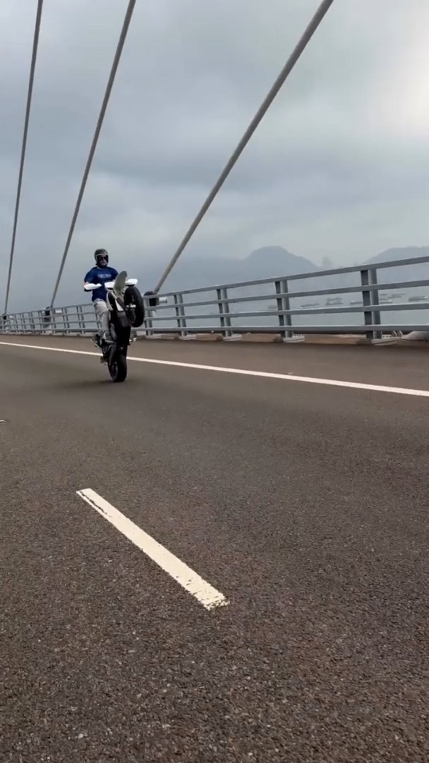 涉事男子騎電單車在昂船洲大橋上駕駛時，玩「後輪騎」（Wheelie）特技。（Instagram影片截圖／@surron_london）