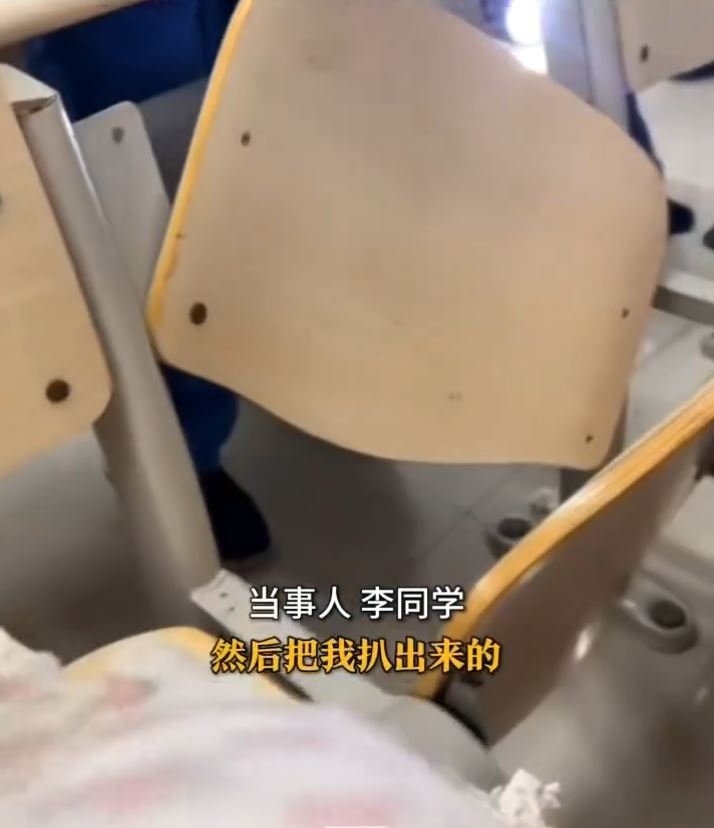 學校工作人員取來工具，將椅子背板拆開，之後七人合力將李同學救出。（網上影片截圖）