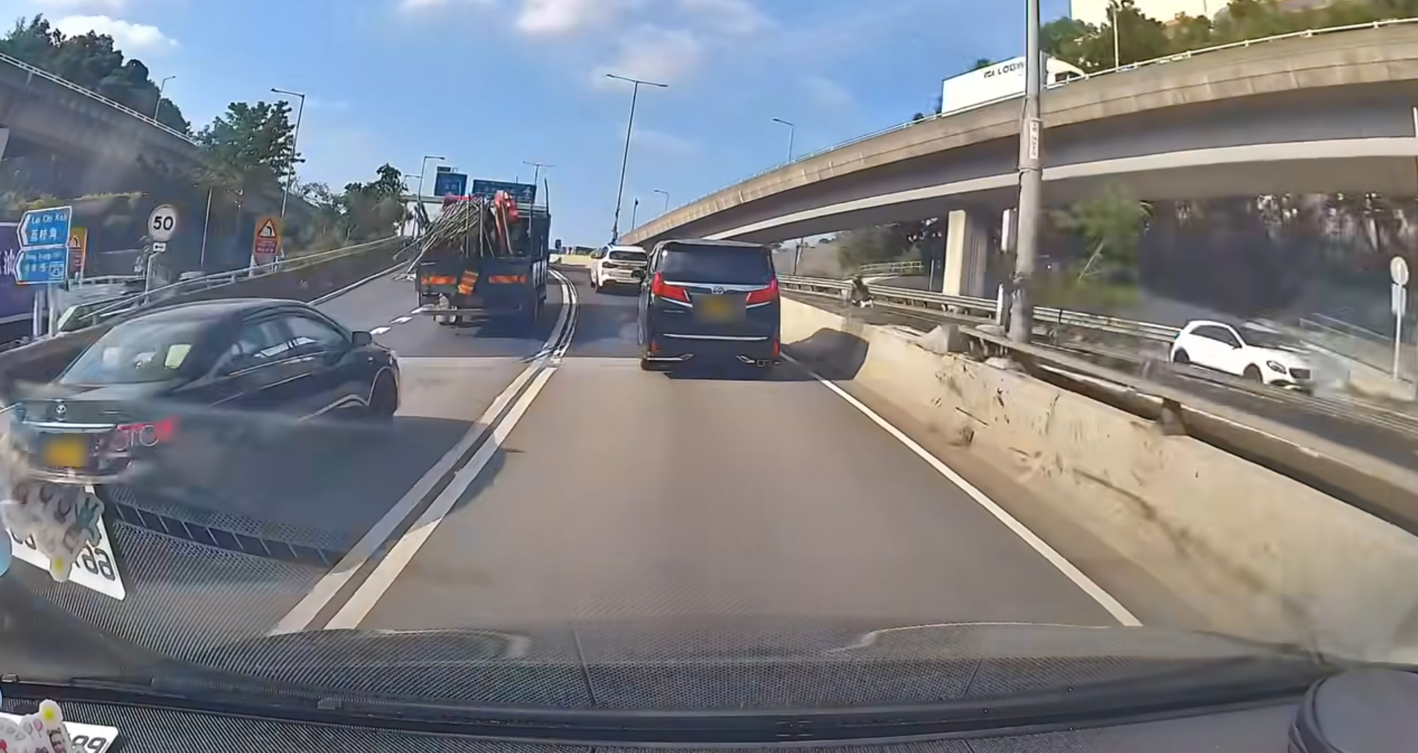 一輛棚車在高速公路行駛，車尾載滿長竹，竹枝尾端懸空伸出，沒有任何紅旗或防護墊，場面驚險。