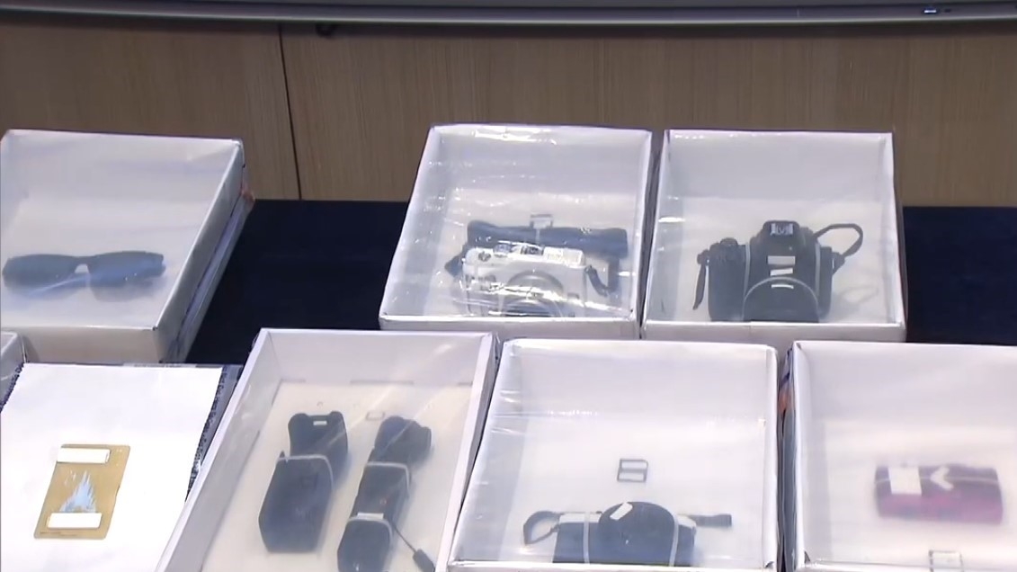 行動中入境處人員檢獲被捕人士的攝影器材及道具、化妝用品和手提電話。