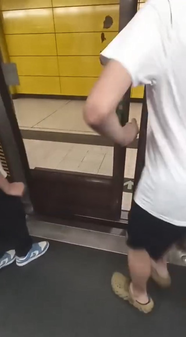 在月台幕門幾乎完全關上時，兩名男子立即「縮腳」退回車廂內。（網上片段截圖）