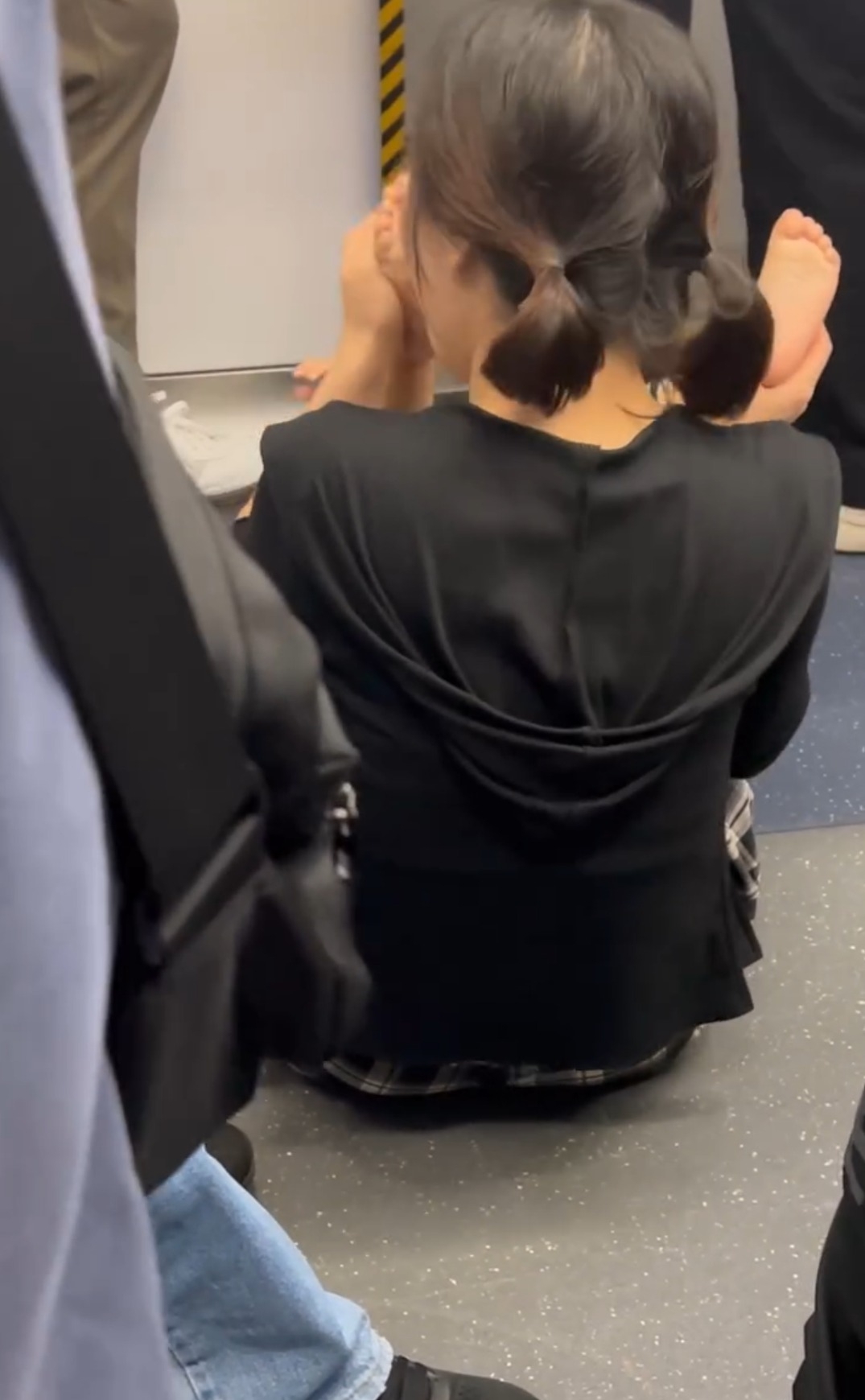 一名母親在車廂內席地而坐，並將其子躺於地上，期間不斷舉起其雙腳並聞之，一邊稱「好臭」，一邊重複動作，引起車廂內乘客側目