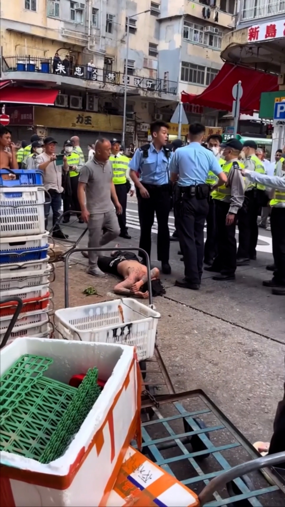 一名赤裸上身、有紋身的男子伏在地上。（Facebook影片截圖／車cam L（香港群組）／馮先森）