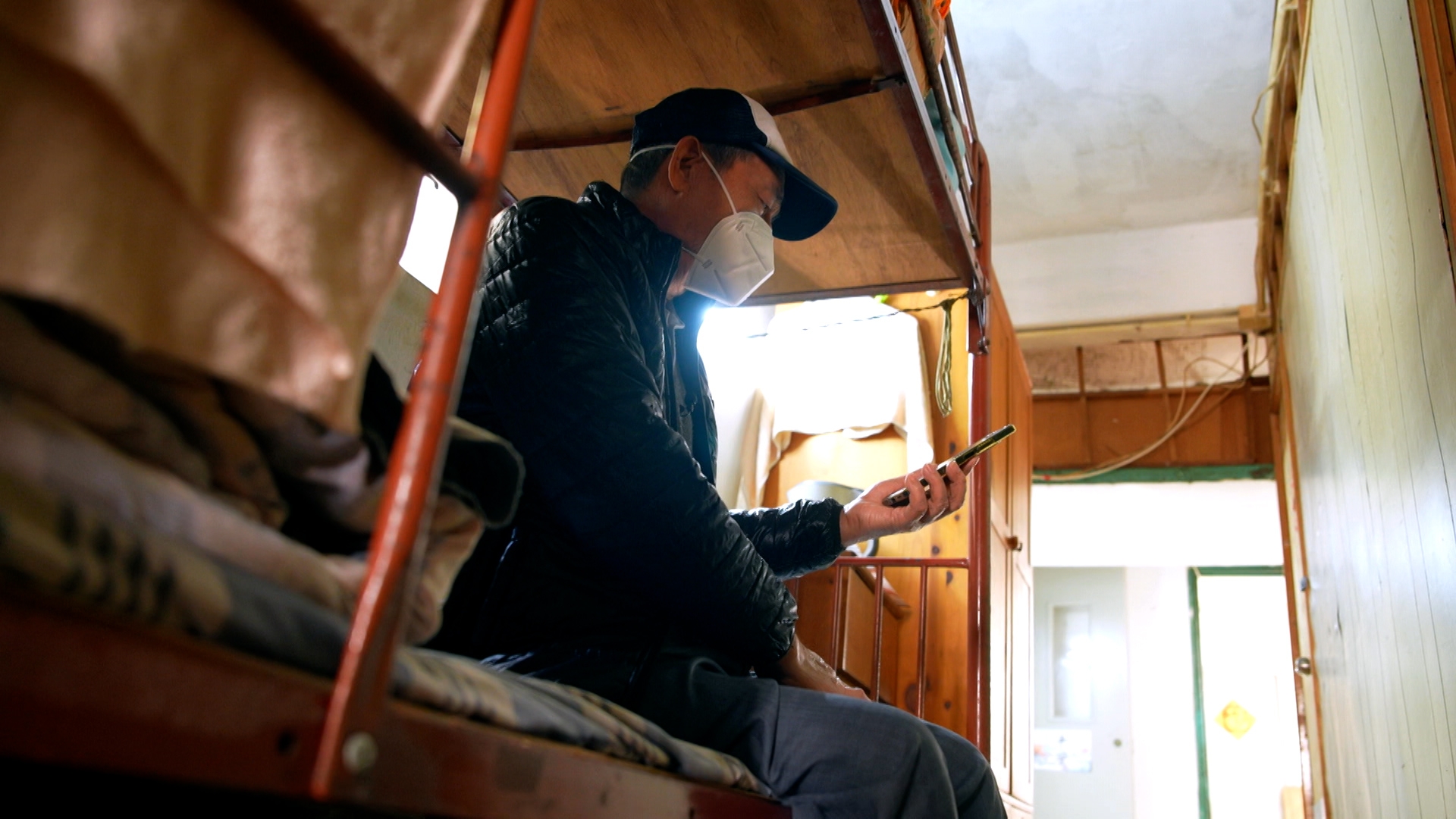 在同一棟大廈，住在B號門牌的譚伯，以2千元租住位於走廊的床位，這張床就是他這十年的「蝸居」。