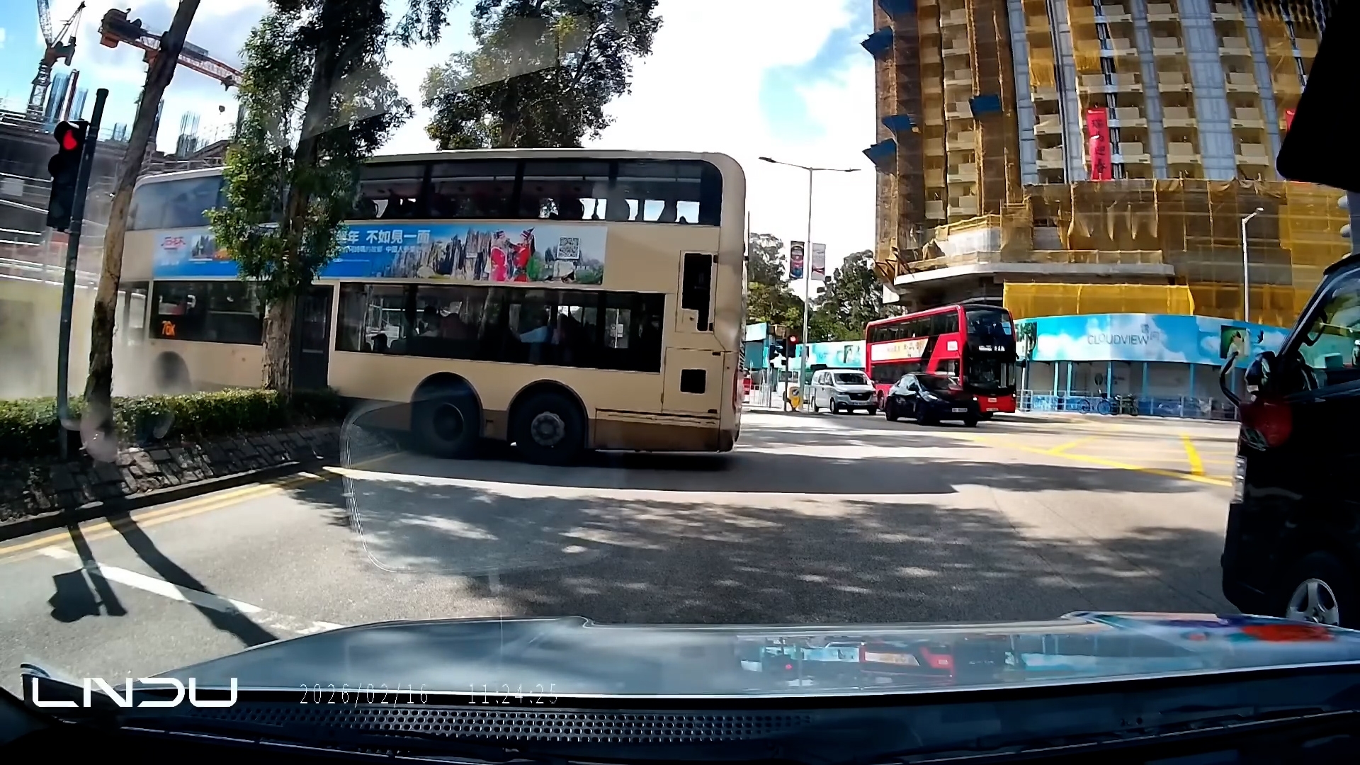 巴士車身前端剷入行人路，更險撞向醫院新北翼工程地盤圍板。（網上影片截圖）