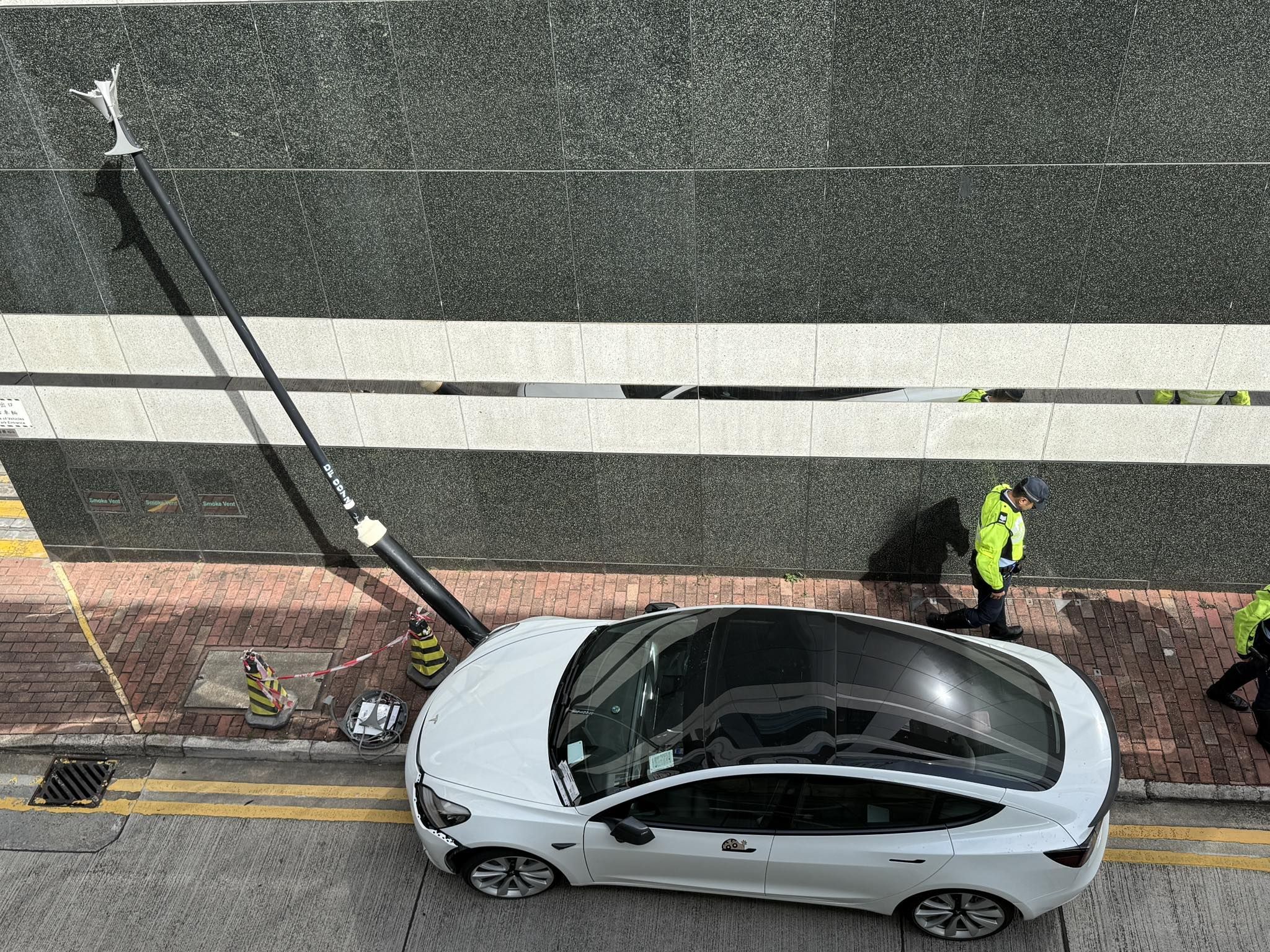 Tesla剷上尖東行人路撞爛燈柱司機不顧而去　警員車頭攝「牛肉乾」罰錢