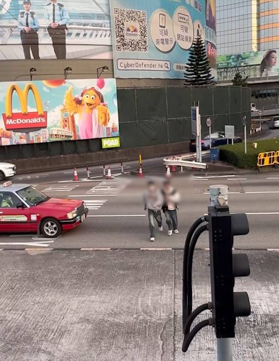 兩男誤闖紅隧口過馬路，最後要職員帶走。(T@nicola223)