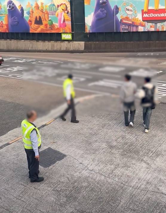 兩男誤闖紅隧口過馬路，最後要職員帶走。(T@nicola223)