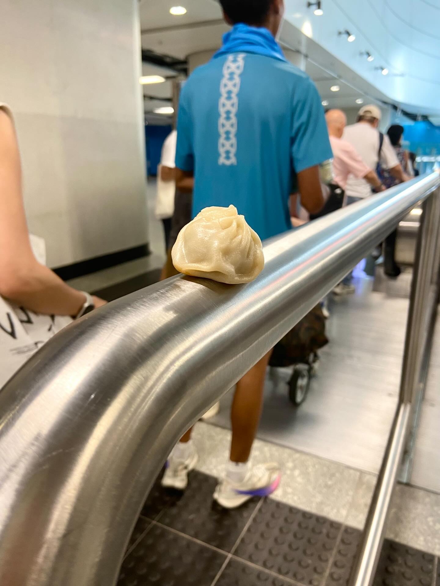 在金鐘站一處扶手電梯前，有一個小籠包被放置在欄杆上。（Threads圖片／felix.prfm）