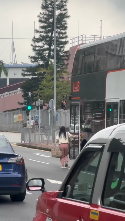 女子荃灣衝馬路拍門追巴士勁牙煙，司機終開門放行被網民鬧爆。(影片截圖／Threads@z.oeyi)