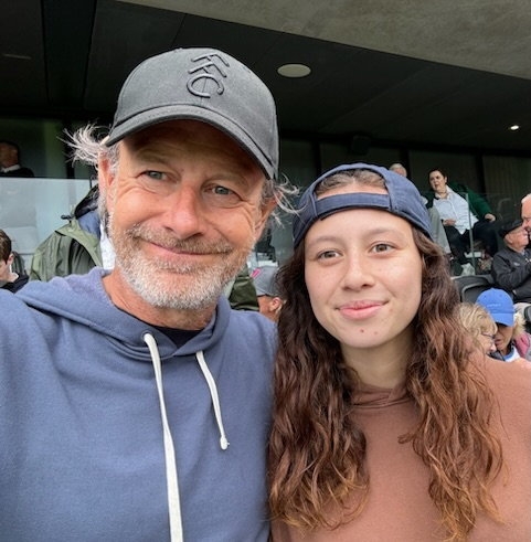 A man and a young woman, likely father and daughter, smiling at the camera.