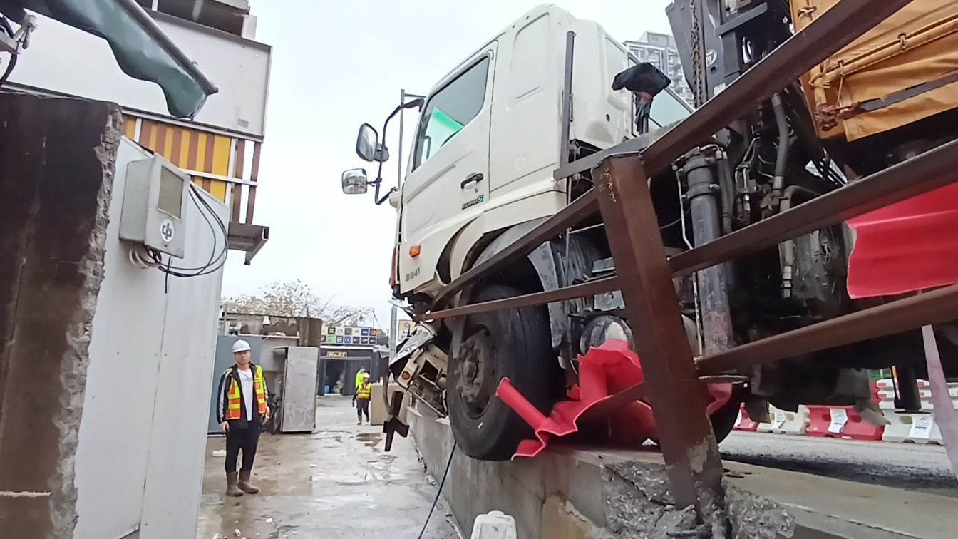 元朗吊臂車疑天雨路滑失控，撞欄及水馬更險衝入村屋。