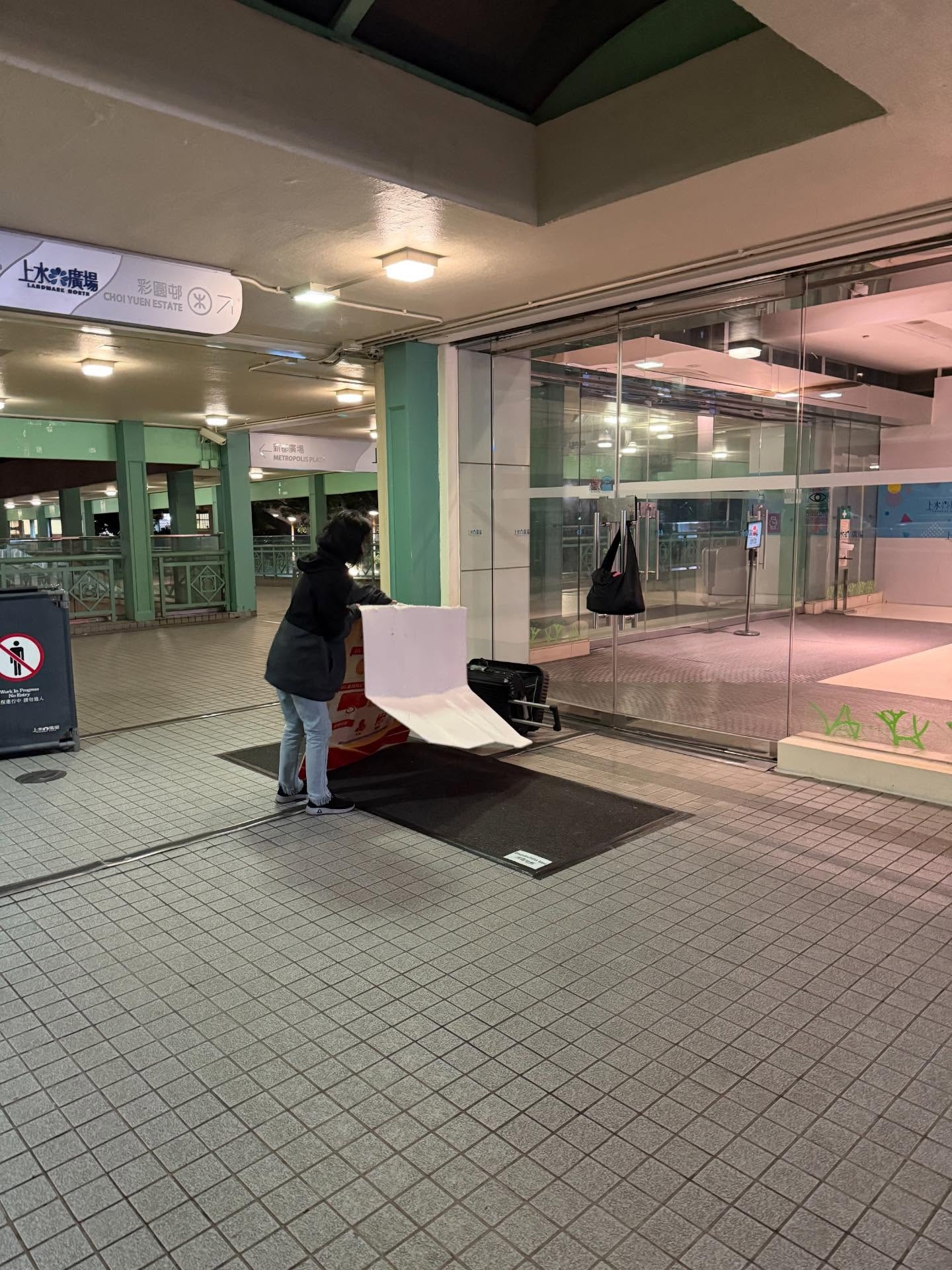 上水廣場疑內地旅客玩「窮遊」瞓街，舖紙毯攤消毒地毯過夜。 (網上圖片@threads)