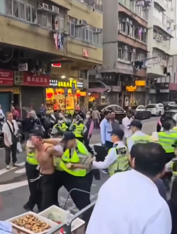 赤膊男不斷試圖掙脫，但被食環署人員一左一右合力成功制服。（Facebook影片截圖／香港突發事故報料區及討論區／Yuki Ng）