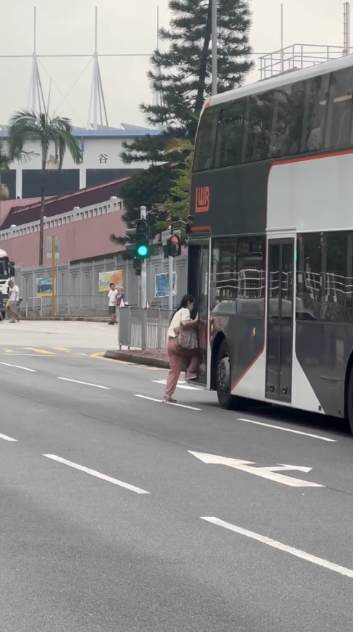 女子荃灣衝馬路拍門追巴士勁牙煙，司機終開門放行被網民鬧爆。(影片截圖／Threads@z.oeyi)