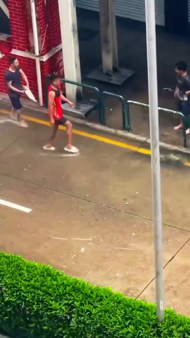 在澳門水浸的街道上，有民眾在嘗試捉魚，以及成功將新鮮魚撿走。（Threads影片截圖／babiwii）