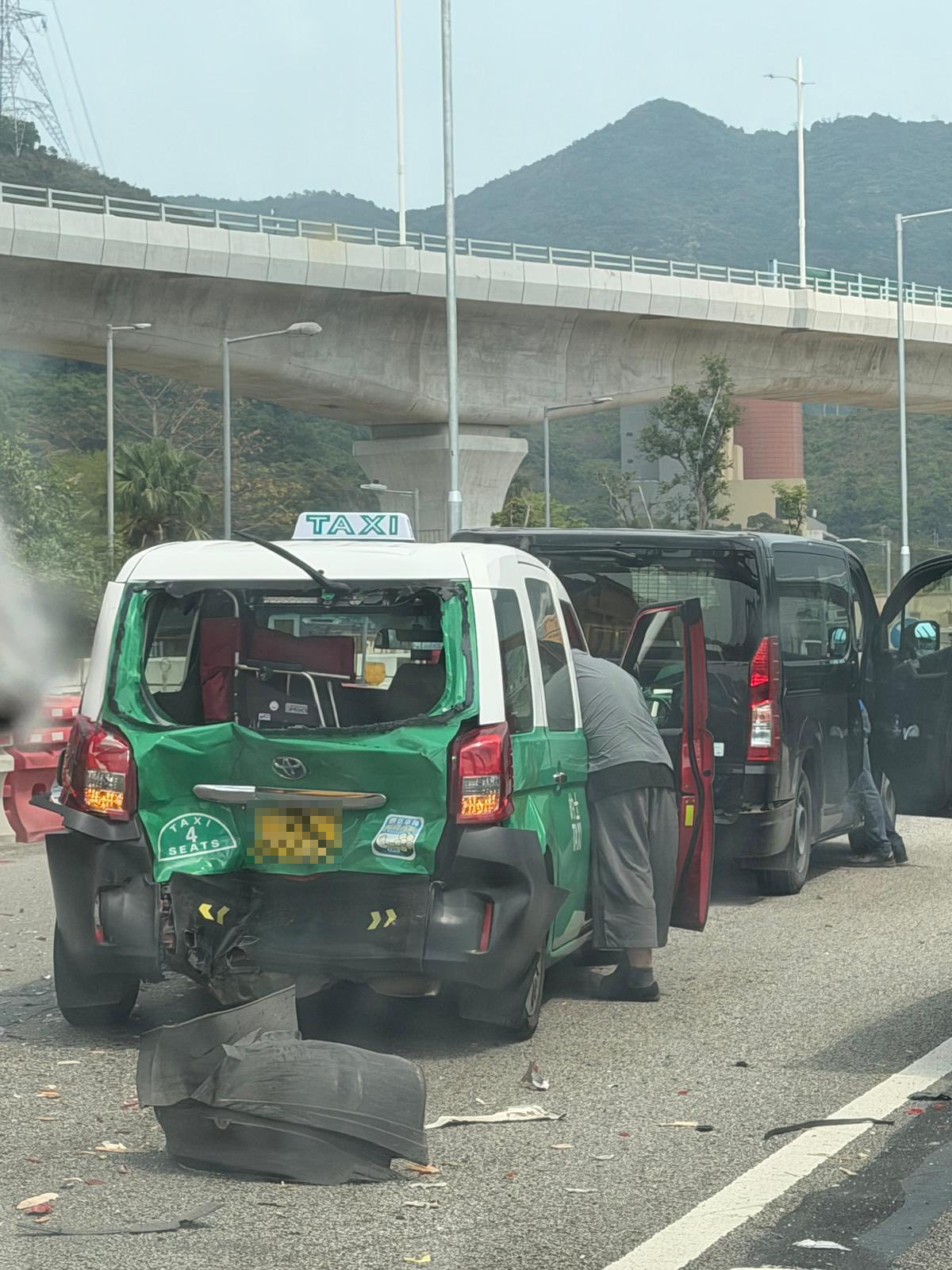 事發後，其中一輛客貨車嚴重損毀，後門甩脫，車身變形扭曲，彷如廢鐵，涉事的士車尾亦有凹陷。（Facebook圖片／馬路的事 (即時交通資訊台)／Bosco Chu）