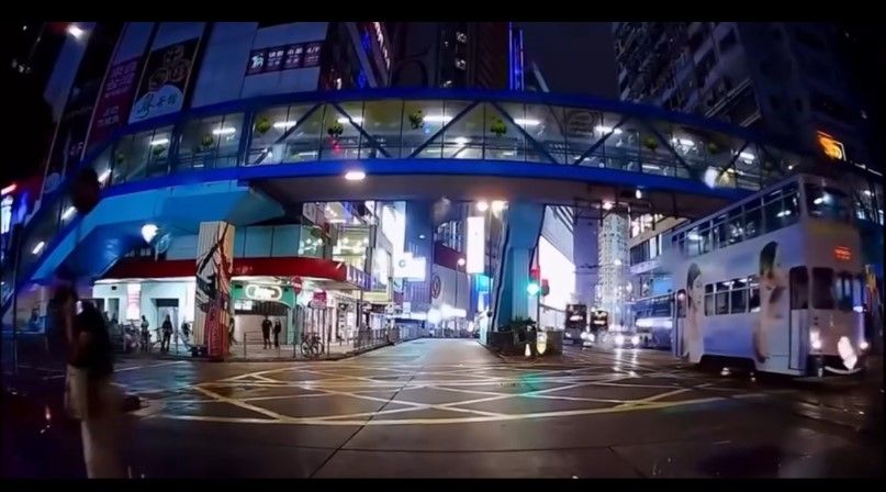 銅鑼灣內地女冒雨急步「衝紅燈」，插水跣入的士底險遭輾過。