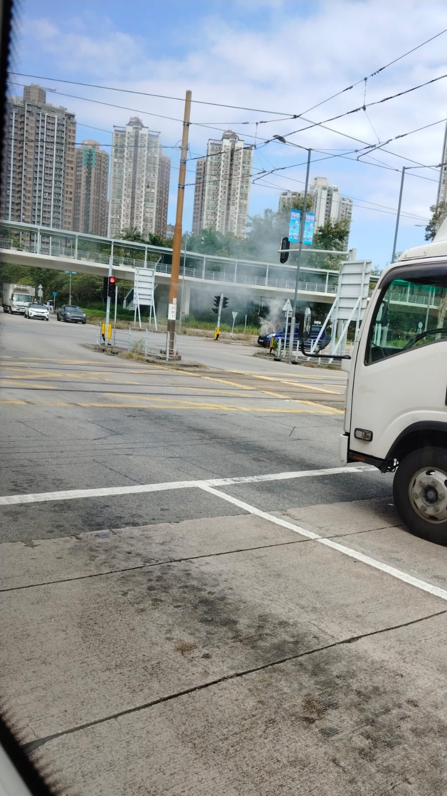 涉事客貨車停泊在青田路與鳴琴路交界的燈位前，車輛陷入火海，大量濃煙冒出，直衝半空，警方及消防人員趕到現場處理事件。（Facebook圖片／車cam L（香港群組）／Bosco Chu）