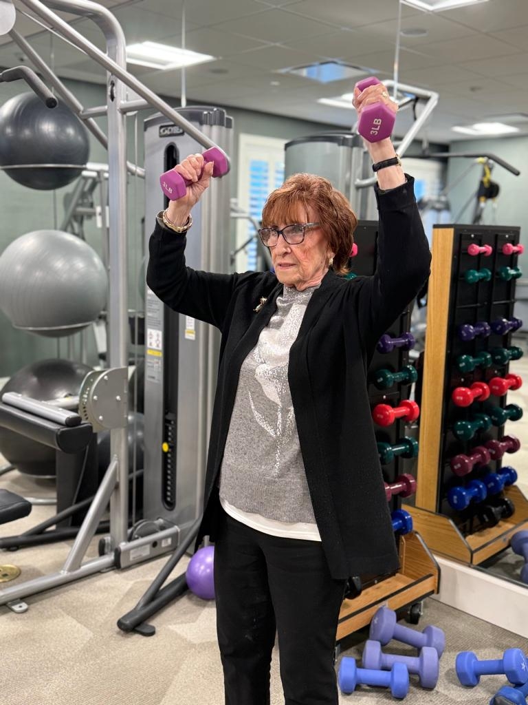 雪莉·戈德曼在健身房用兩個3磅重的啞鈴鍛鍊。