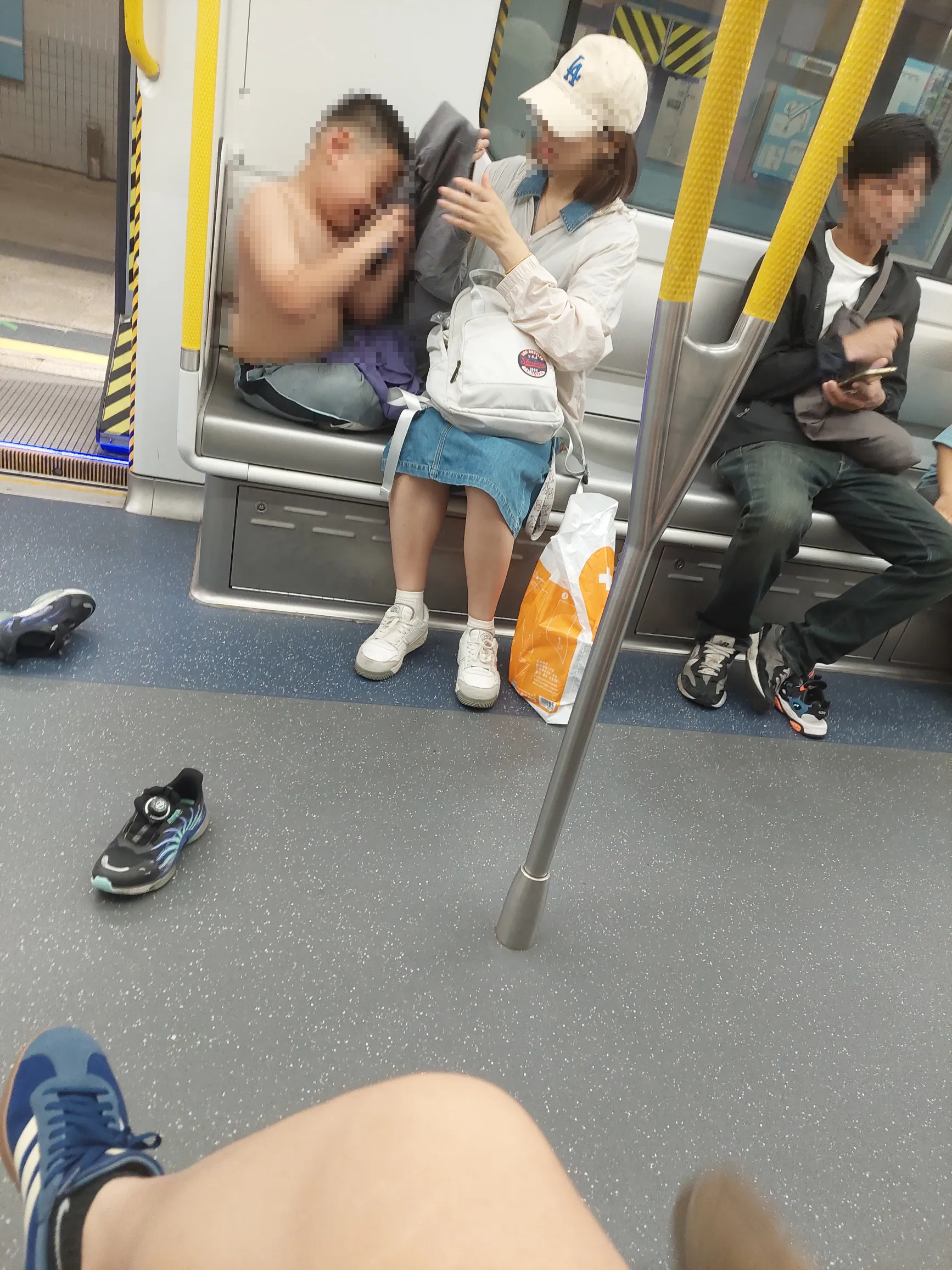 一名男童疑在母親幫忙下脫掉上衣，男乘客則一臉無奈地坐在中間。（Threads圖片／key.6_8）