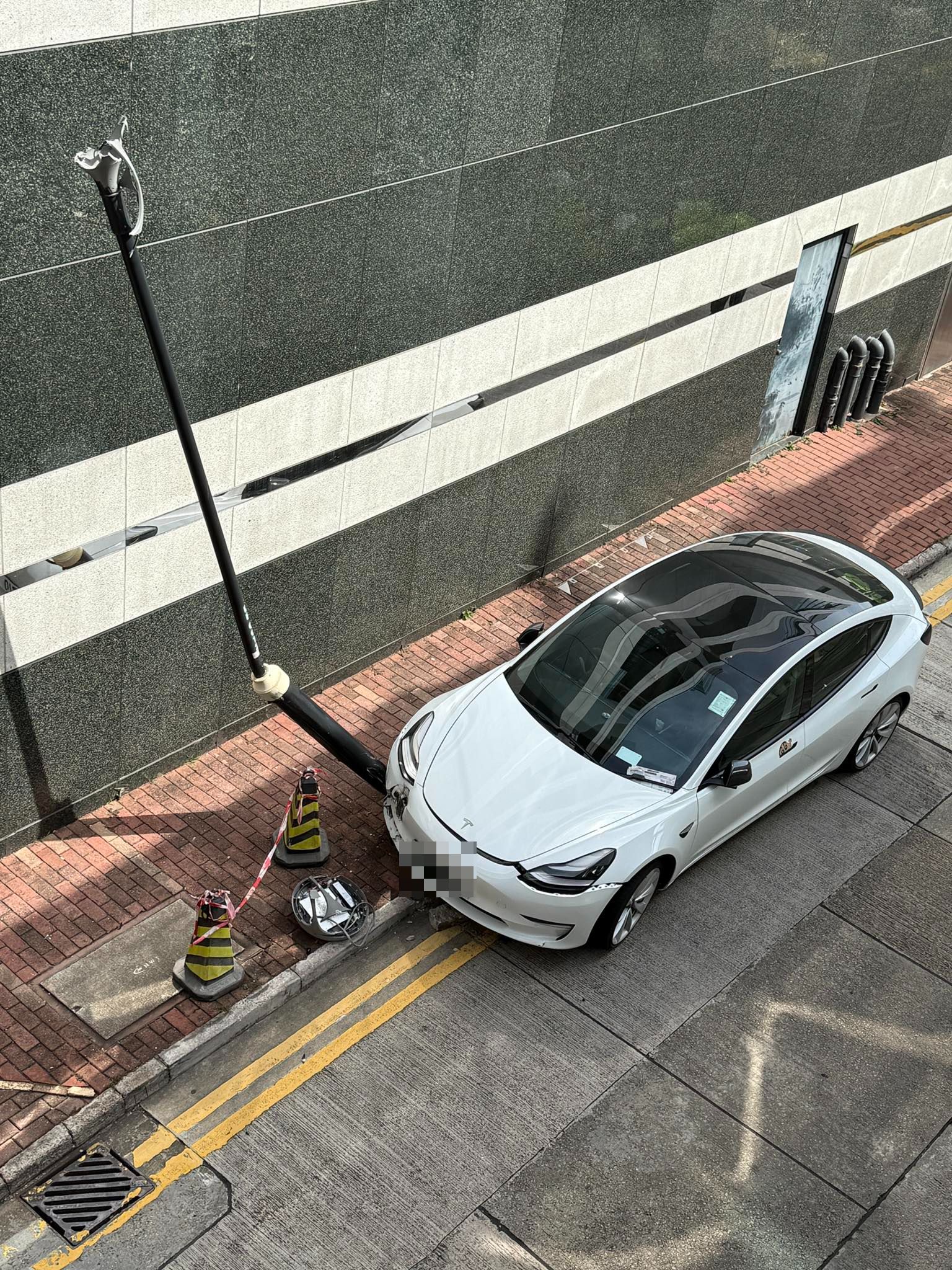 Tesla剷上尖東行人路撞爛燈柱司機不顧而去　警員車頭攝「牛肉乾」罰錢