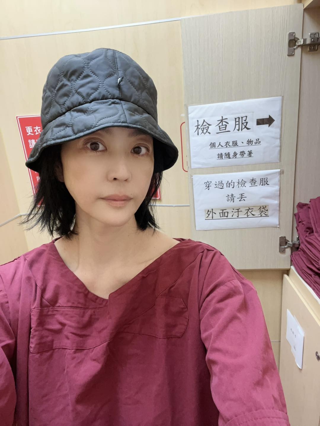 May be an image of 1 person, hat and text that says '更衣 更衣 請 檢查服 個人衣服、物品 物品 個人衣服 請隨身猪著 穿過的檢查服 請丟 外面汙衣袋'
