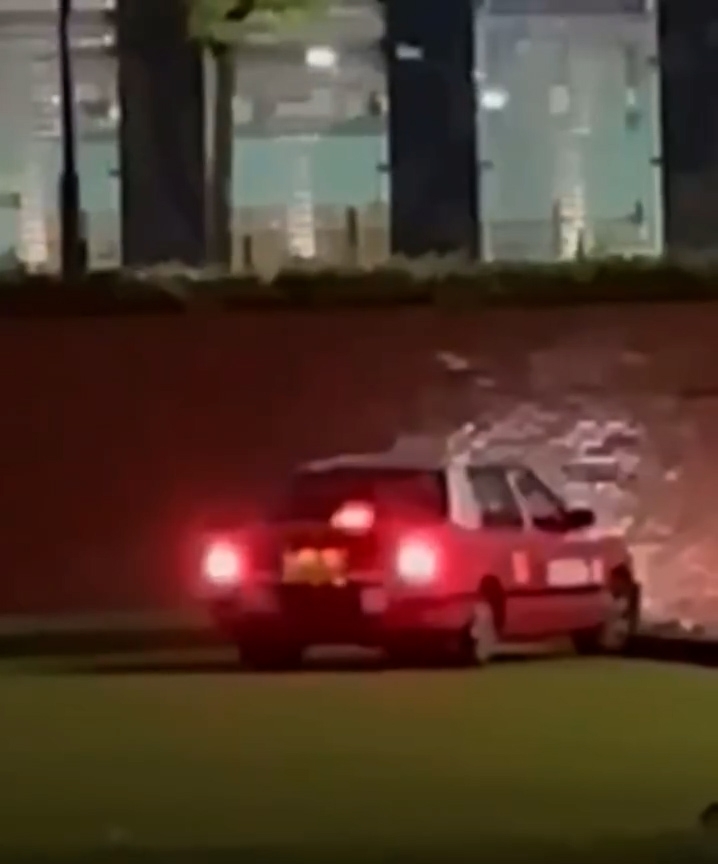 一輛載客的士在晚間駛入紀利華木球會的草坪，經過多番前進和倒車，仍未能成功離開草坪。（Facebook影片截圖／車cam L（香港群組）／Akakin Li）