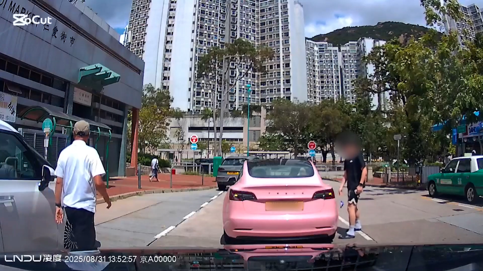 在屯門仁愛街市對出，一輛粉紅色Tesla停在馬路上，一名男子在該輛Tesla旁丟下一塊垃圾在路面上。（Facebook影片截圖／車cam L（香港群組）／Wong Kong） 