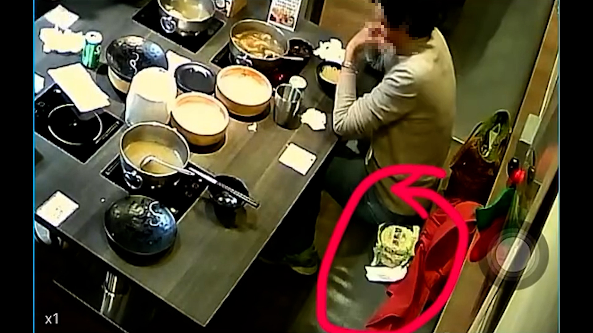 吃完火鍋後，坐在靠牆位置的老婦，把多包未拆包裝的麵放在座位旁邊，再迅速把麵放入手袋，動作一氣呵成。（Threads影片截圖／ciel.ying）