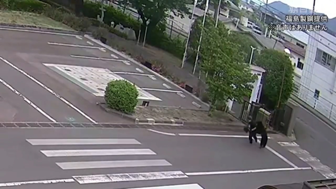 男員工嘗試逃跑擺脫野熊不果，野熊從後把他撲倒，之後跑進旁邊一幢建築物。（Threads影片截圖／@osakapleb）
